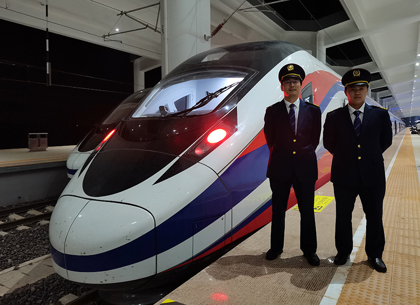 劉銀能（右一）與中國師父鄔俊鴻在動(dòng)車組前合影。受訪者供圖